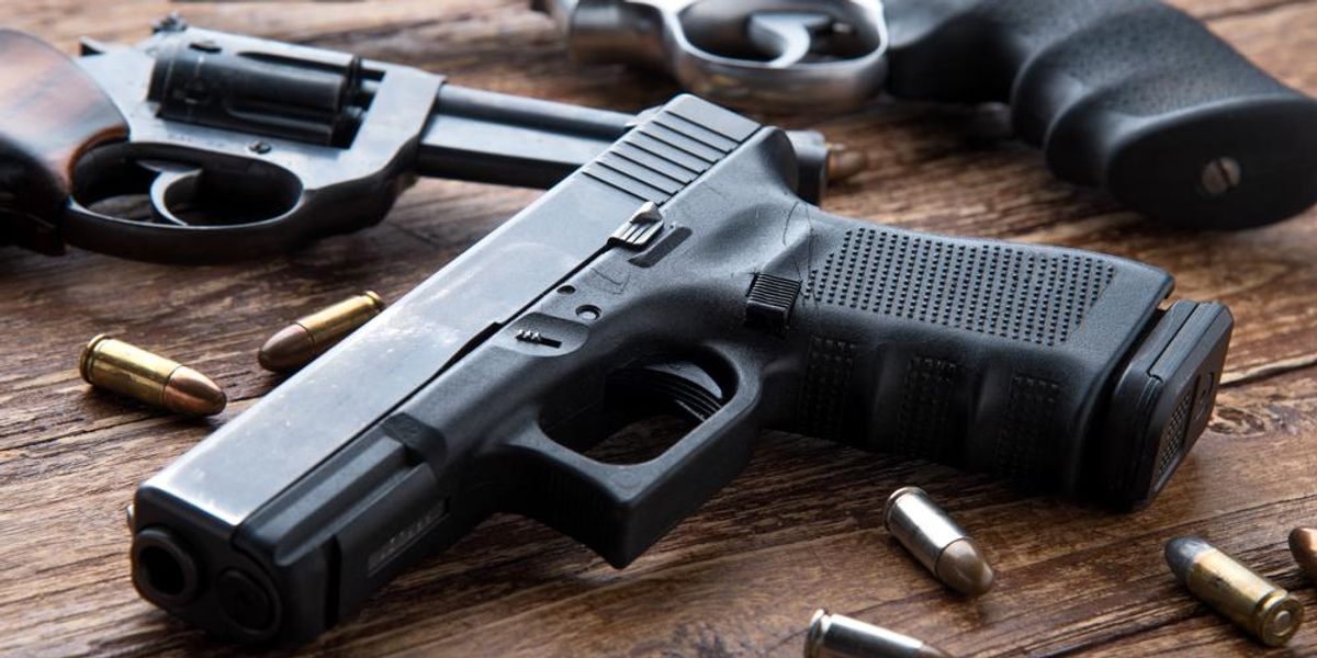 9 milliméteres fegyver revolverekkel egy fa asztalon, amelyen lövedékek találhatók