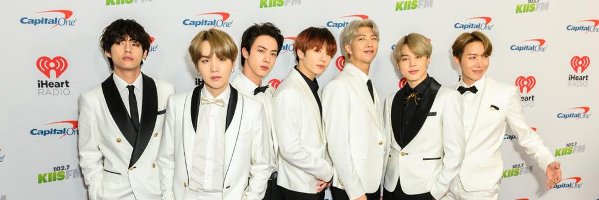 A BTS K-pop fiúbanda hét tagja a vörös szőnyegen fehér zakóban