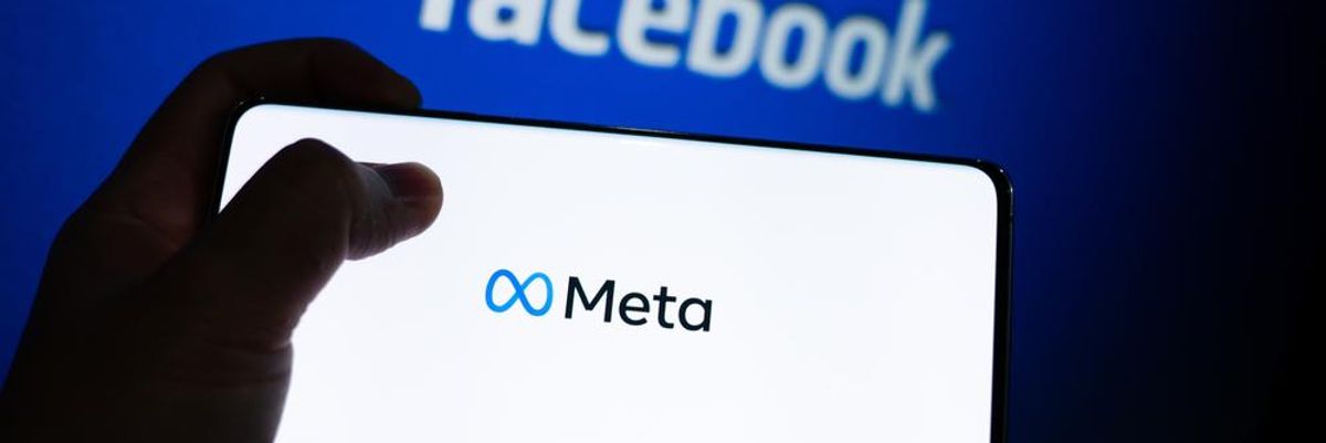 A Facebook logója előtt látható egy telefonon a közösségi oldal új neve, a Meta