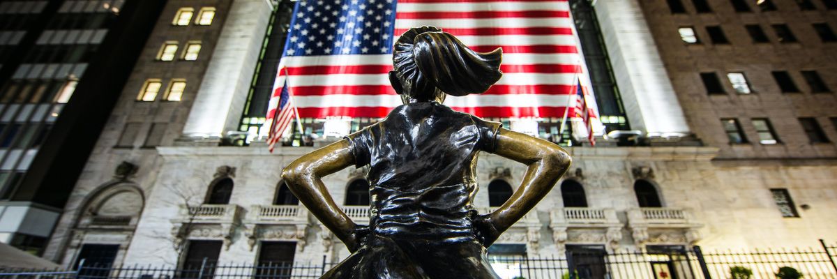 A Fearless Girl szobor a Wall treet-en az amerikai zászló előtt, éjszaka