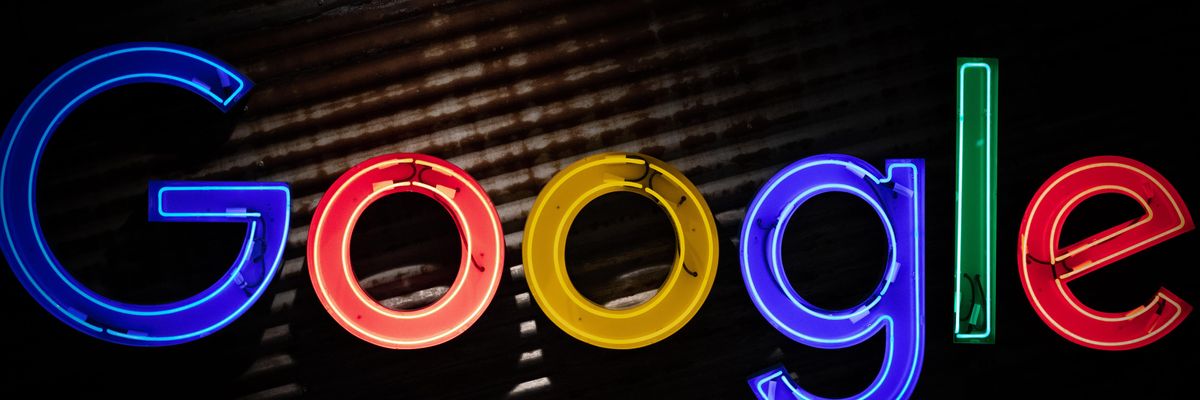 A Google logója kék, piros, sárga és zöld betűkkel, sötét felületen, középen megvilágítva