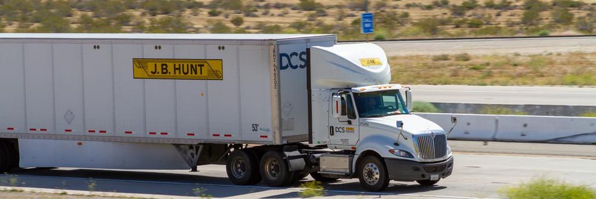 A J.B. Hunt teherfuvarozó vállalat egyik kamionja benne a kamionsofőrrel aki az autópályán, nappal vezeti a kamiont