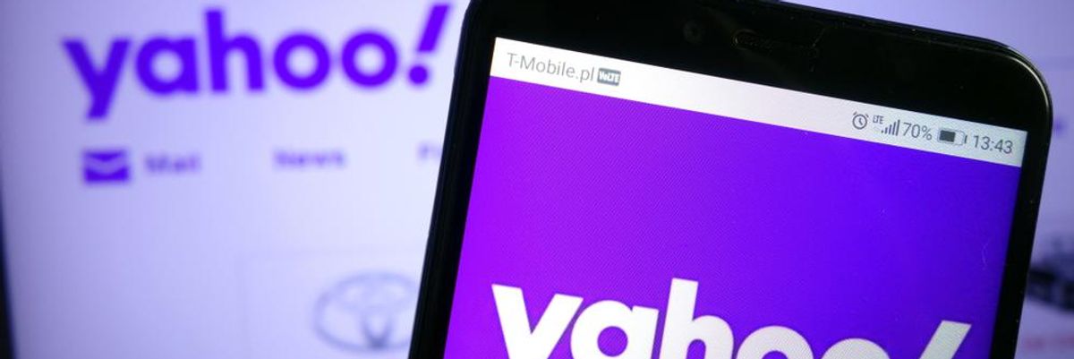 A Kínából frissen kivonult Yahoo vállalat applikációja tölt egy ember okostelefonján, amit a kezében tart