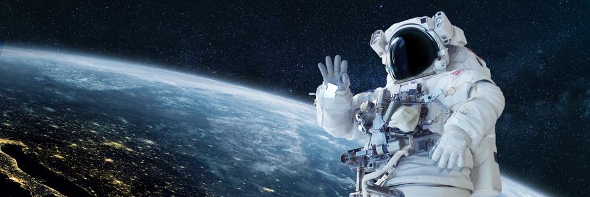 A NASA űrhajósa szkafanderben integet a kamerának a Föld felett egy űrséta közben