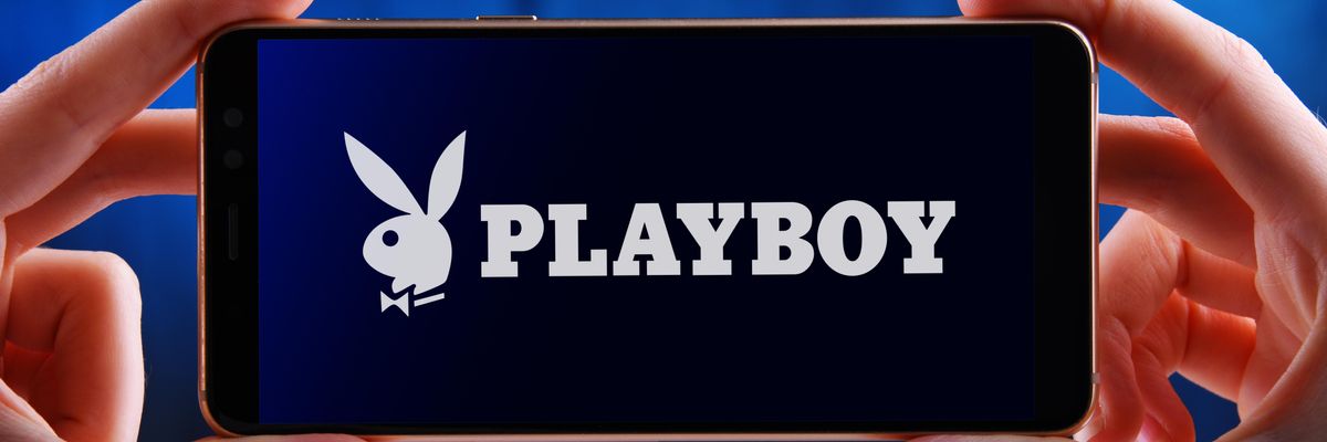 A Playboy logója egy okostelefon képernyőjén, amit egy ember tart a kezében