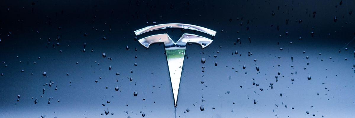 A Tesla emblémája egy kék színű járművön
