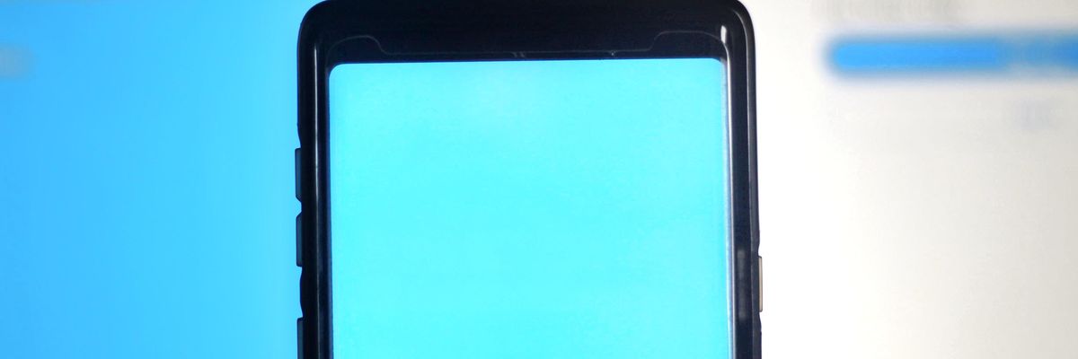 A Twitter logója, egy fehér madár kék háttérben látható egy okostelefon kijelzőjén 