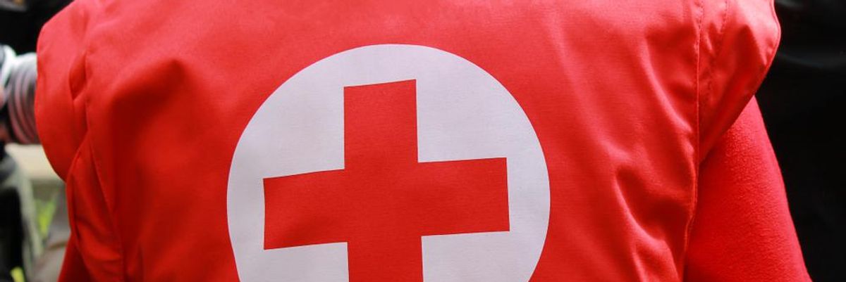 A Vöröskereszt piros-fehér logója egy segélyszervezeti tag piros mellényének hátulján