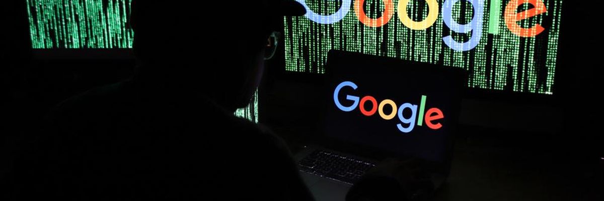 Adatvédelmi szakember baseball sapkában egy sötét szobában figyeli a Google-t, amelynek logója több képernyőn is látszik