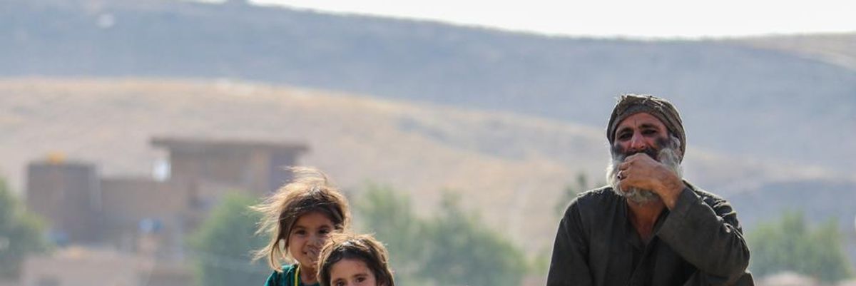 Afganisztáni lányok mosolyognak egy szakállas férfi mellett, a tálibok nem engedik őket iskolába