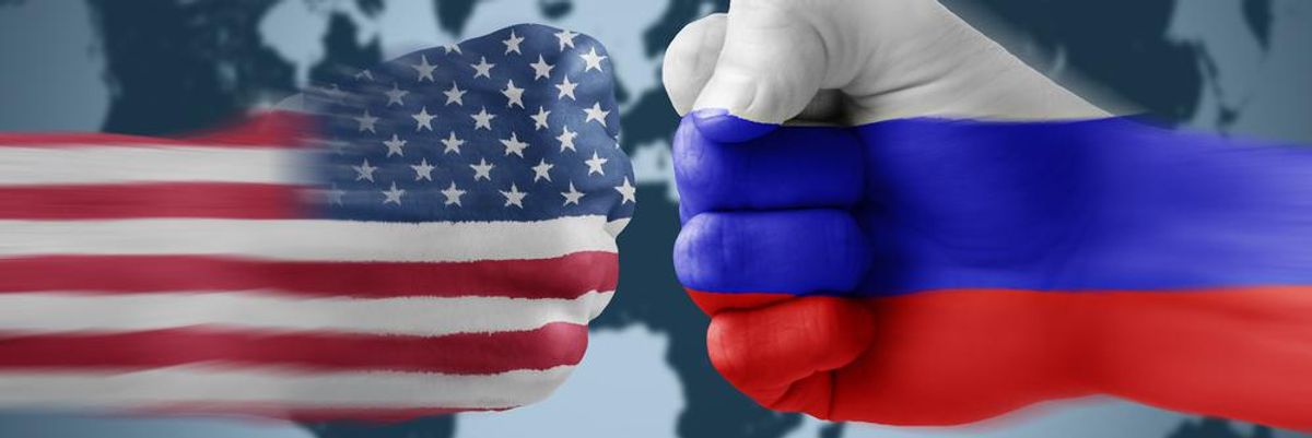 Amerikai és orosz színekre festett, ökölbe szorított kezek ütik egymást a világtérkép előtt
