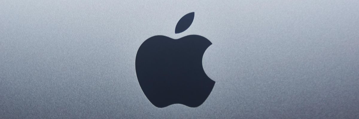 Az Apple logója egy szürkés-fehére laptop hátulján