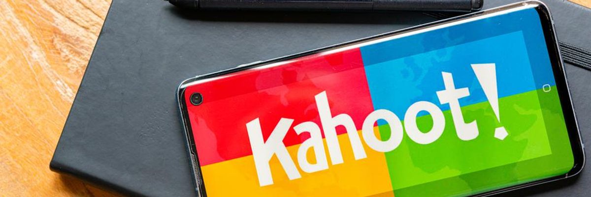 Az ezermilliárdos Kahoot oktatási app kezdőképernyője egy okostelefonon, ami egy fekete noteszen van egy fekete toll mellett