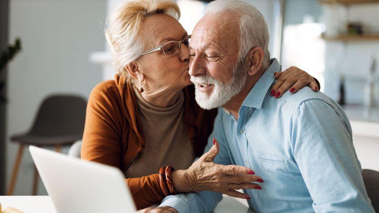 Boldog nyugdíjas pár a laptop előtt