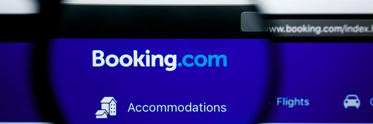 Booking.com szálláskiadó kék logója nagyítóval