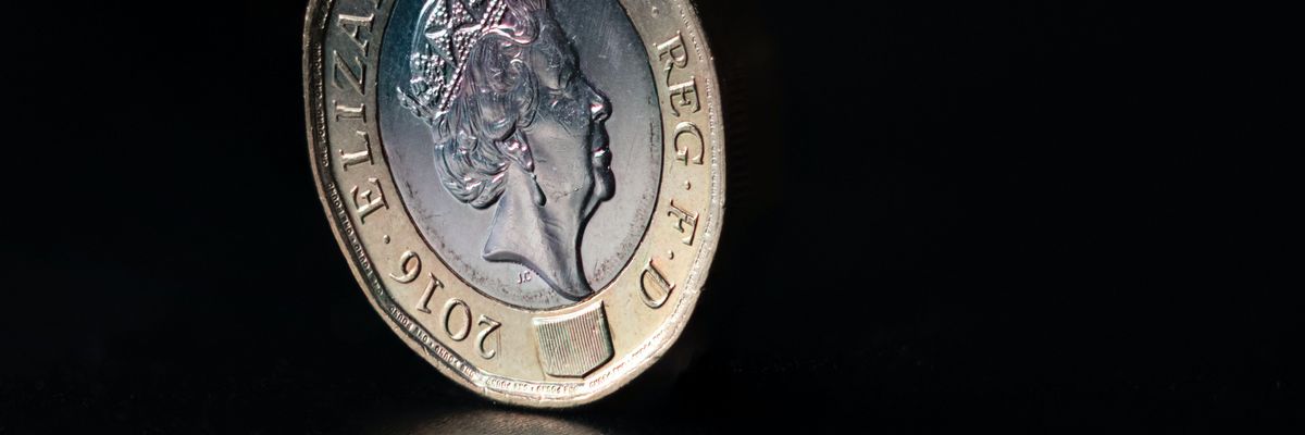 Brit font érme a királynő arcképével sötét háttér előtt