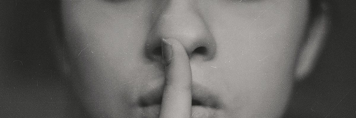 Csendre intő, titkolózó nő puszilgatja az ujját