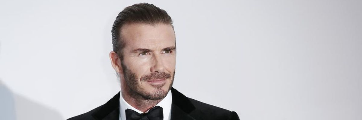 David Beckham szmokingban mosolyog egy fehér fal előtt