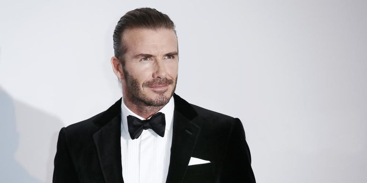 David Beckham szmokingban mosolyog egy fehér fal előtt
