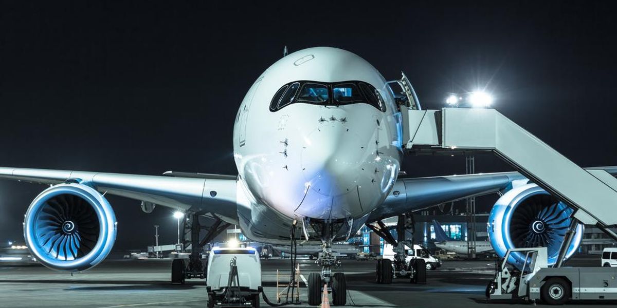 Egy fehér színű Airbus A350-es repülőgép áll a kifutón éjszaka