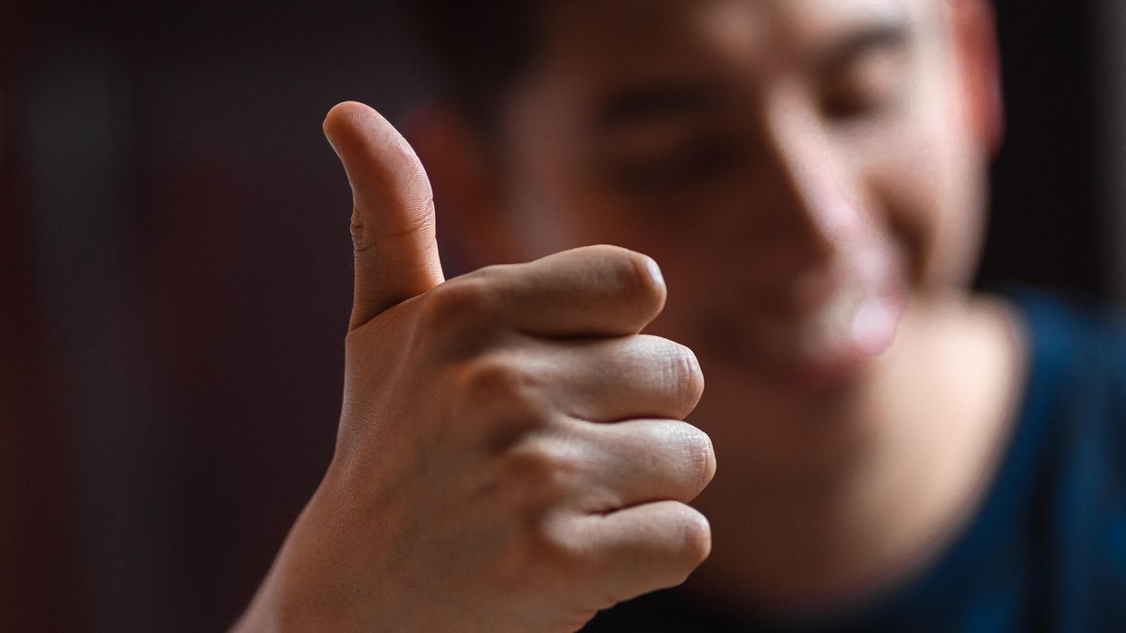 Egy férfi felfelé tartja a hüvelykujját OK-jelet formázva