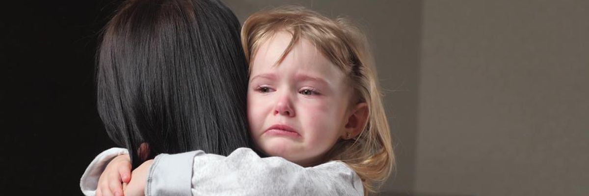 Egy kisgyerek az anyukája ölében sír, mert a szülei nem rendelték meg időben a karácsonyi ajándékokat