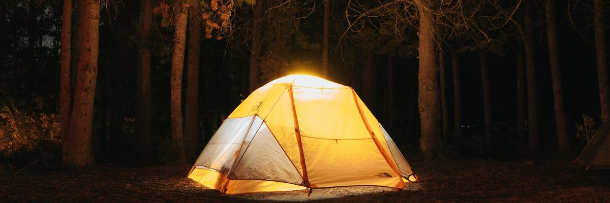 egy kivilágított sátor egy erdőben