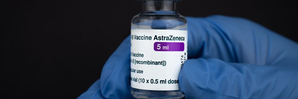 Egy orvos kesztyűben a kezében tartja az AstraZeneca koronavírus elleni oltóanyagát