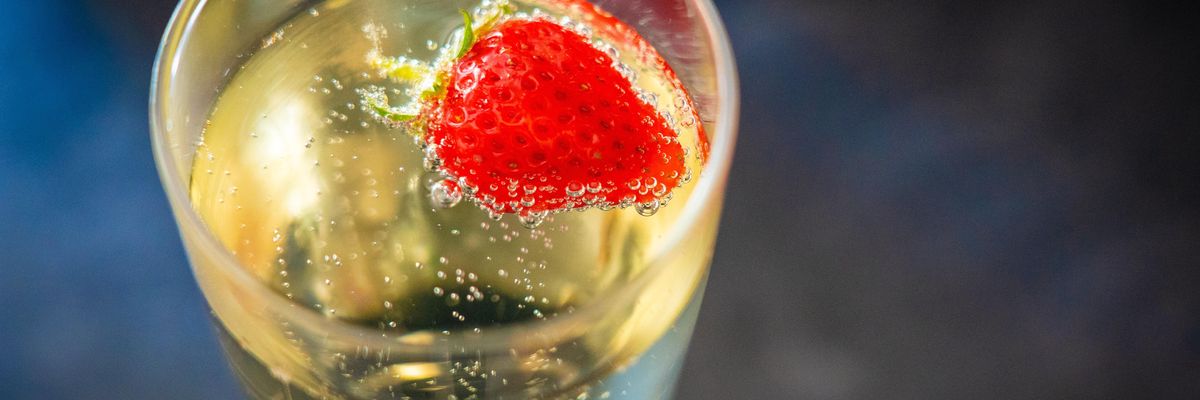 Egy szem eper úszik egy pohár pezsgőben