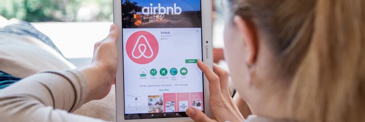 Egy szőke hajú, világos pulóveres lány az Airbnb-t akarja telepíteni tabletjére, miután hallotta, pandémia előtti szinten van az utazási kedv