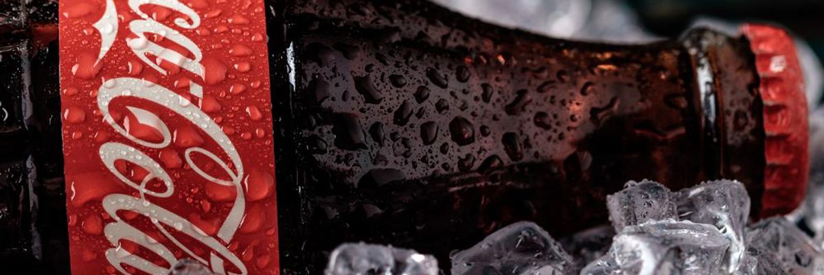 Egy üveg Coca-Cola elfektetve jégkockákon