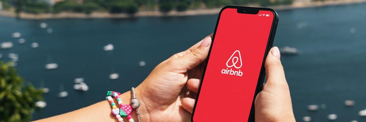 Egy város panorámája előtérben egy okostelefonnal, rajta Airbnb
