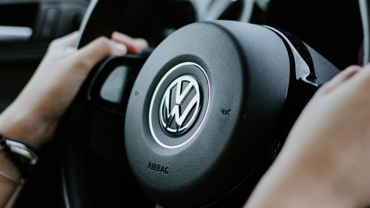 Egy VW-logóval ellátott autókormányt fog egy ember