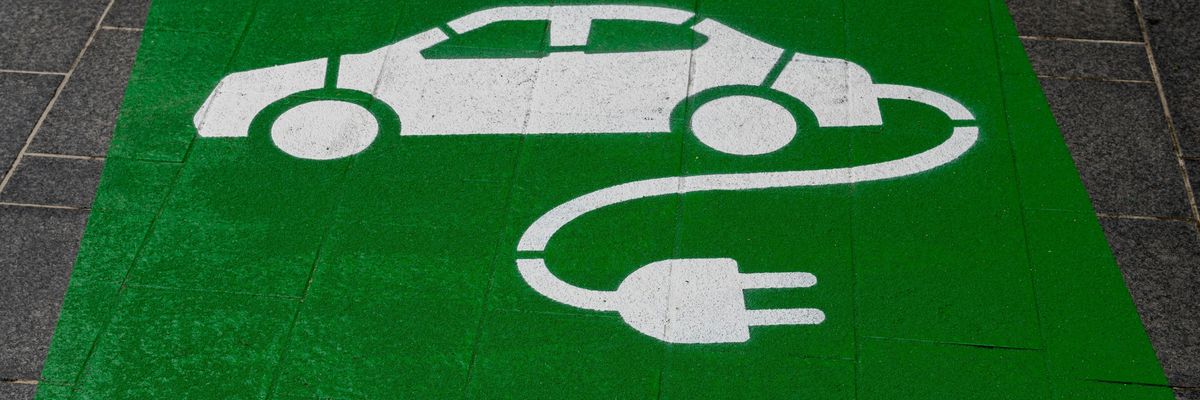 Elektromos autó töltőhely logó a parkolóban a földre festve