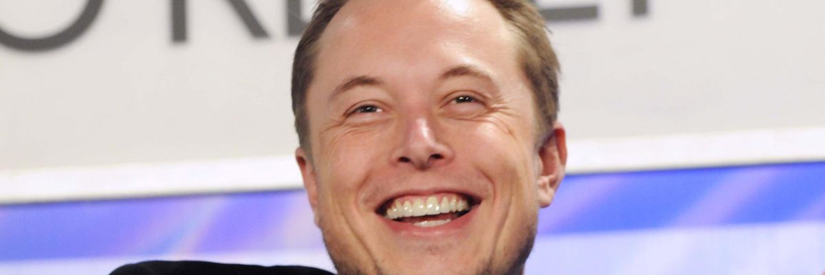 Elon Musk nevet egy székben ülve, táncra perdült a németországi Tesla-gyár átadásán