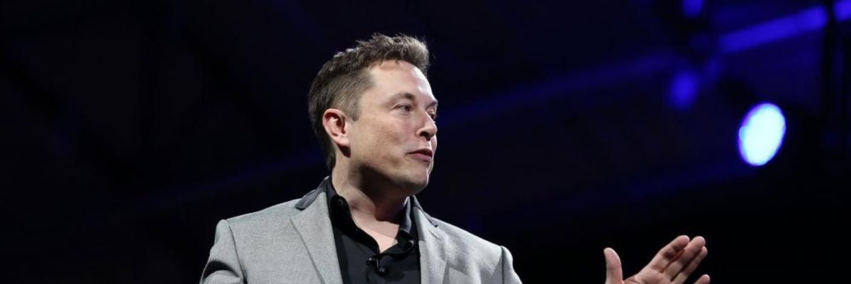 Elon Musk szürke zakóban és fekete ingben beszél az alacsony születési arány veszélyeiről egy színpadon