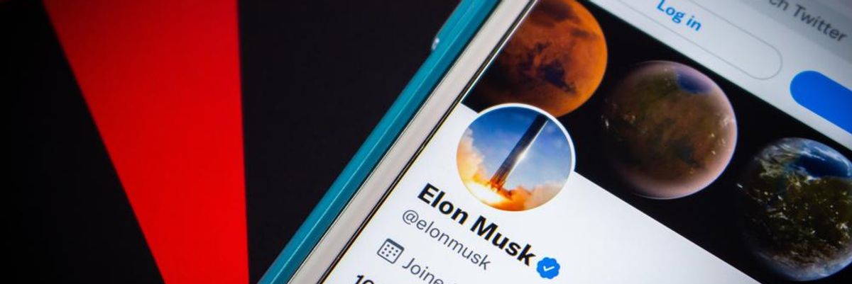 Elon Musk Twitter-fiókja a Tesla logója előtt egy okostelfonon