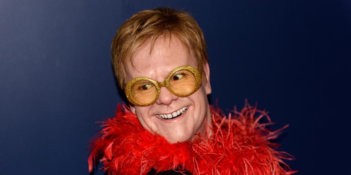 Elton John piros boával a nyaka körül, aranyozott szemüvegben mániákusan vigyorog, miután megtudta, hogy nyilvánosságra hozták a lakcímét