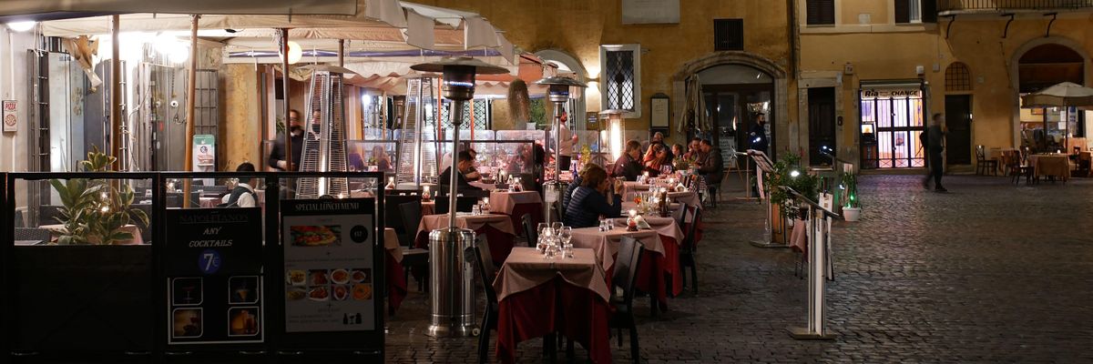 Étterem terasza este egy vársoi téren vendégekkel