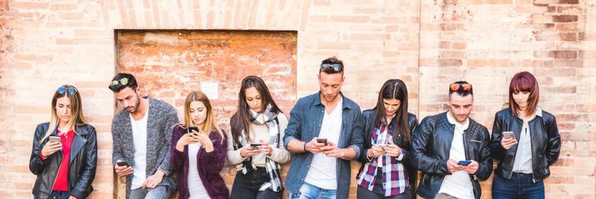 Fiatal felnőttek, az Y generáció tagjai a telefonjukat nyomkodják, és épp arról szavaznak, hogy melyik a kedvenc márkájuk