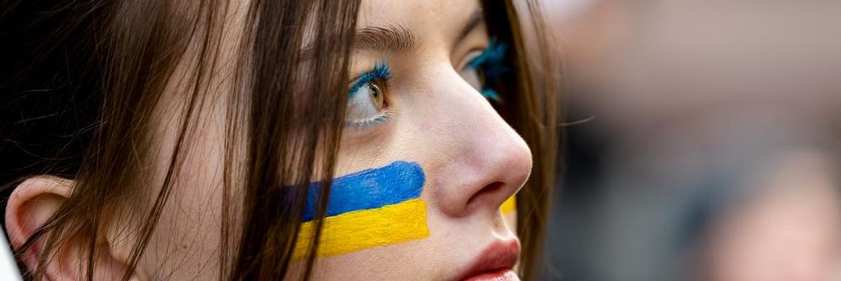 Fiatal lány kék-sárga ukrán színekkel az arcán