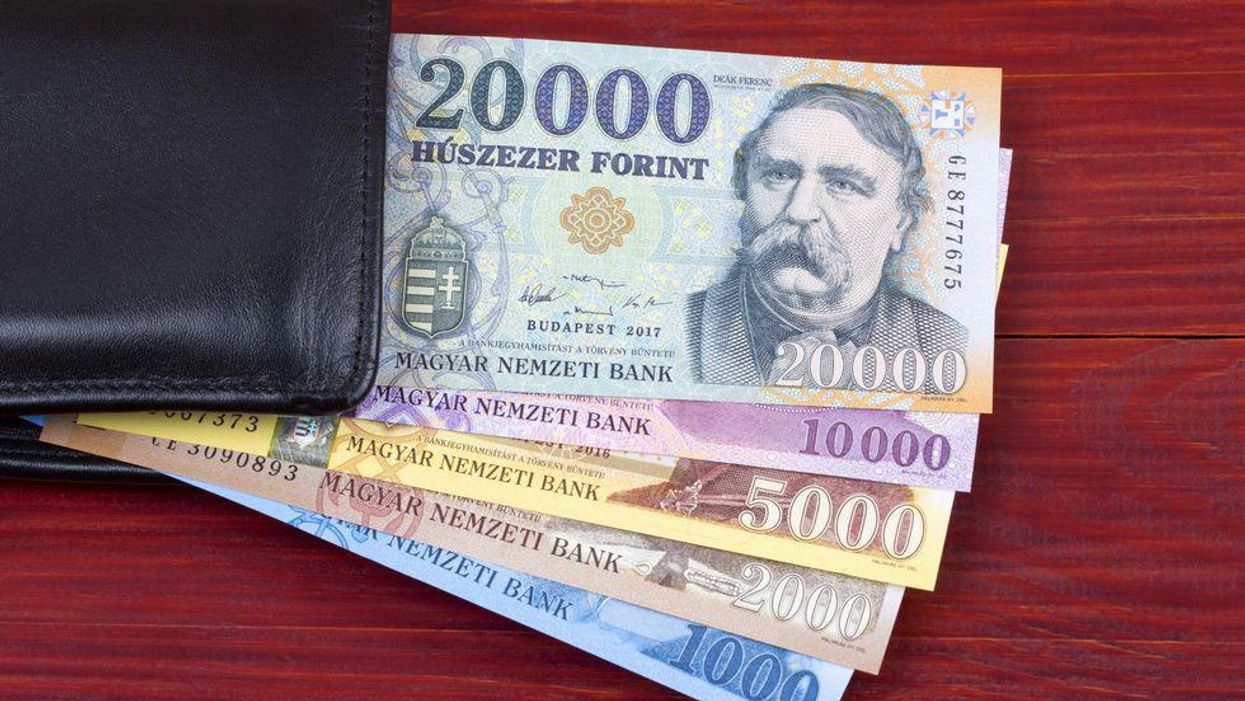 Forintbankjegyek egy pénztárca mellett.