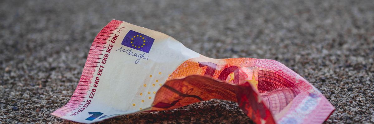 Gyűrött euróbankjegy az aszfalton