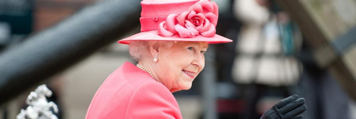 II. Erzsébet királynő rózsaszín kosztümben, rózsaszín kalapban integet alattvalóinak