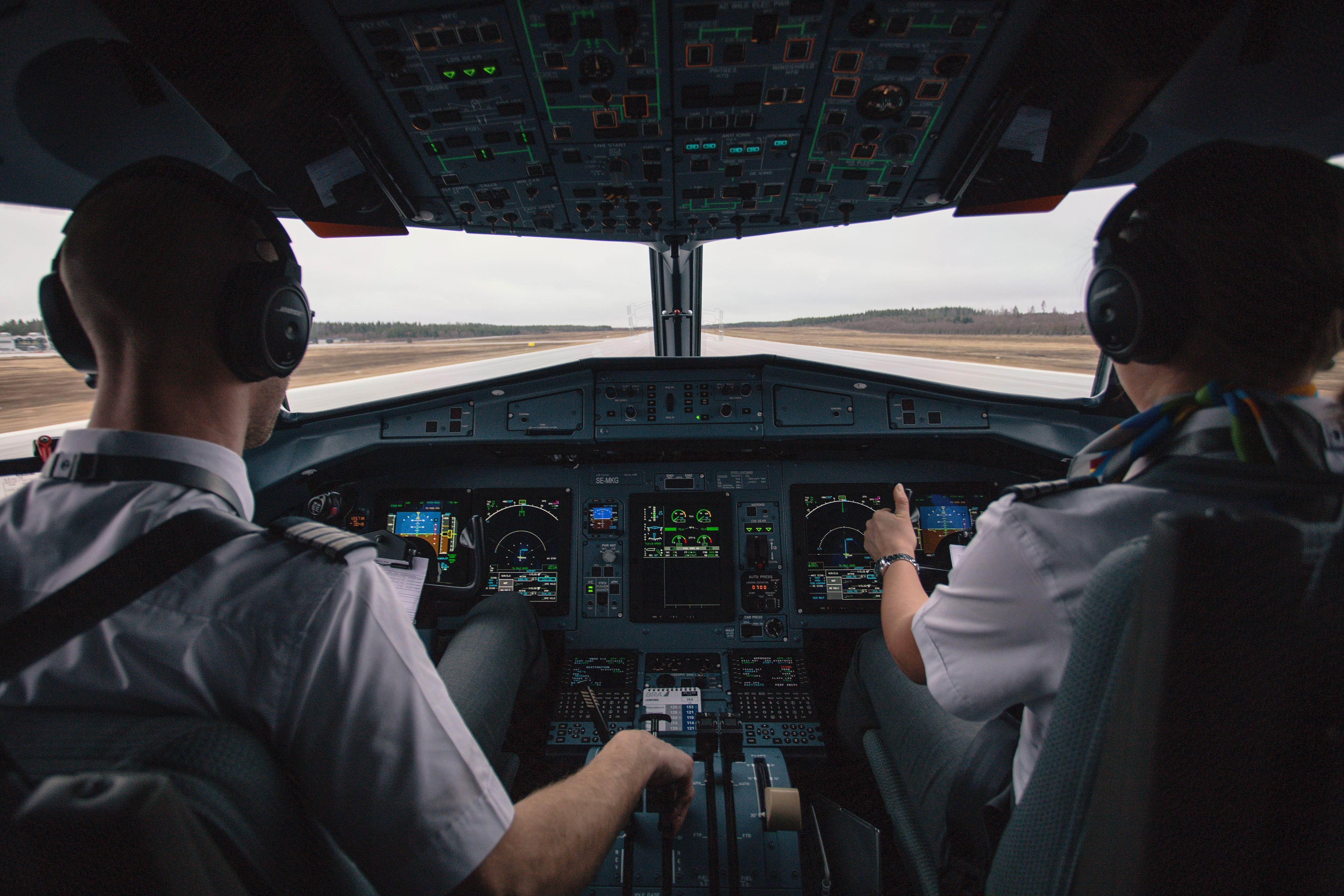 Két felszállásra készülő pilóta a fülkében hátulról