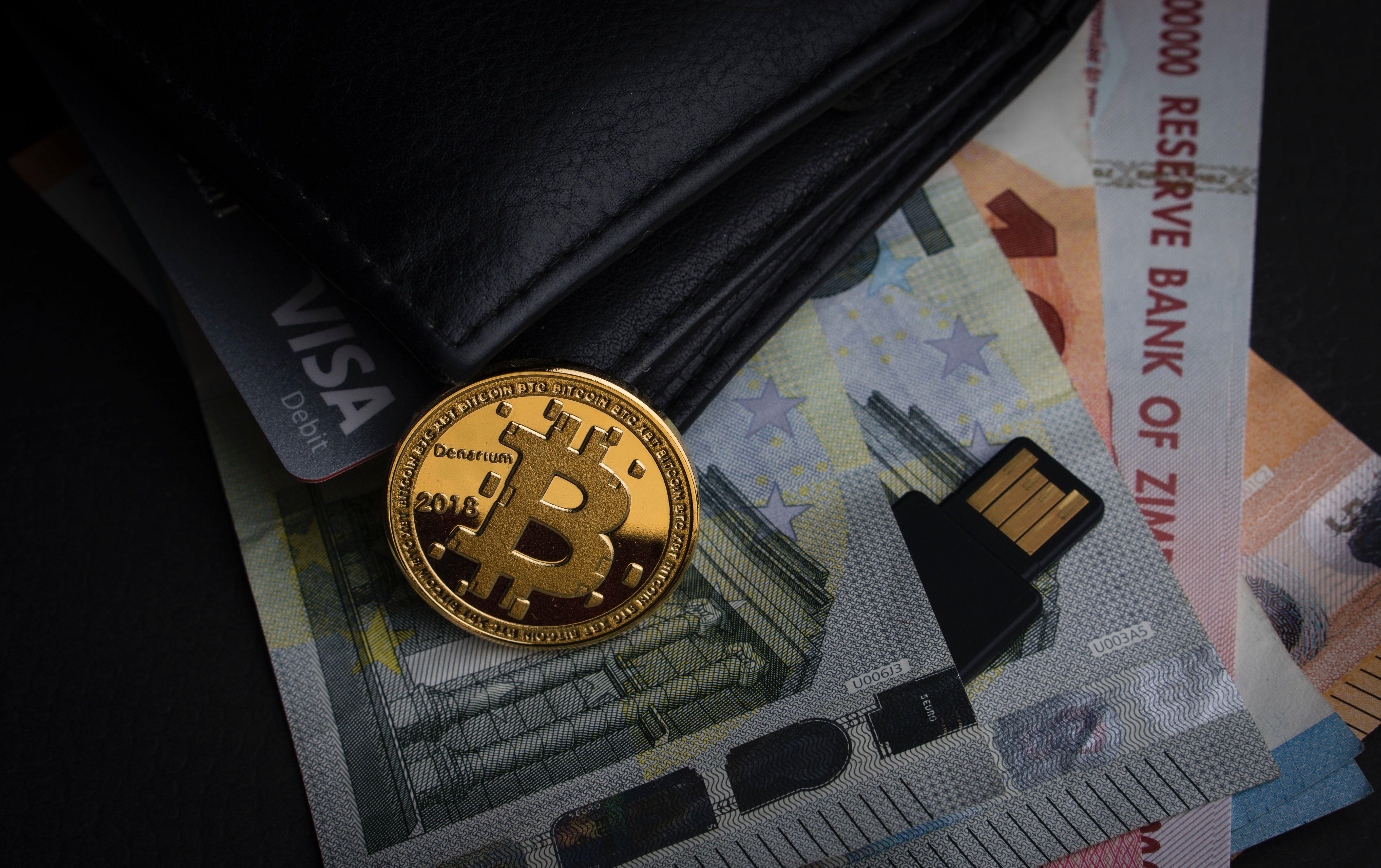 Bitcoin érme pénztárca, bankkártya és bankjegyek társaságában