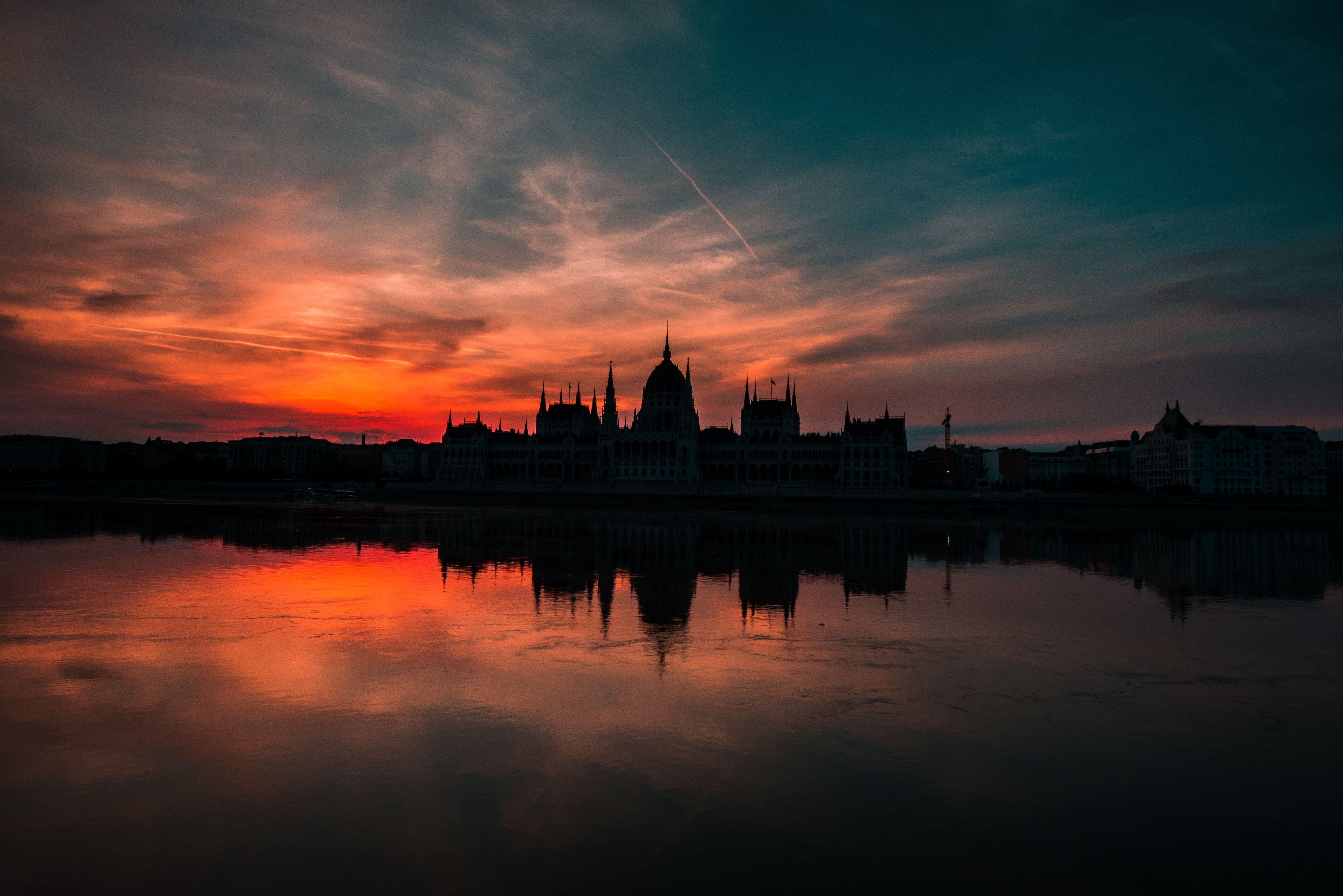 A magyar Parlament épülete a lenyugvó Nap fényében sötétedéskor