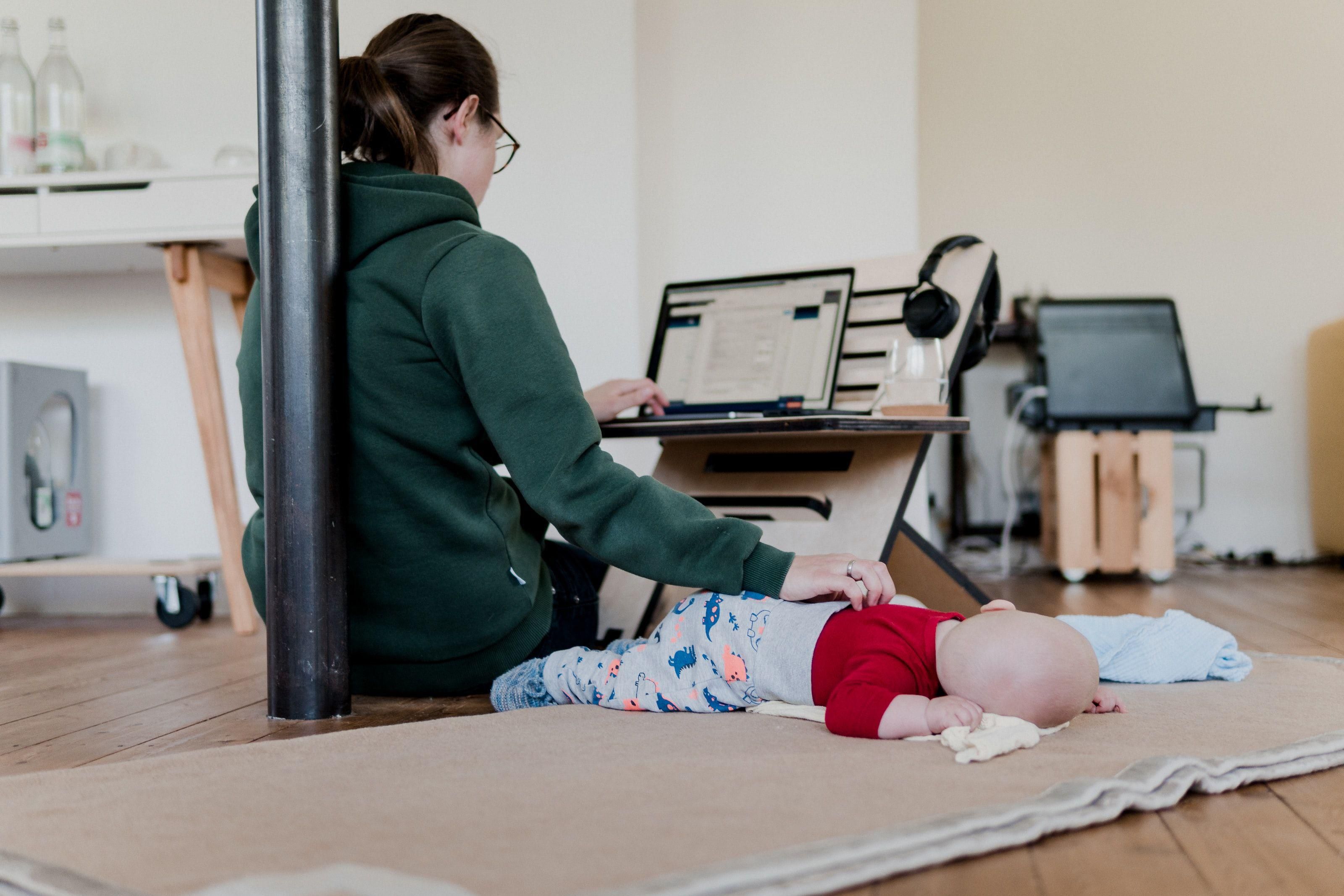 Kisbaba mellett otthonról, számítógépen dolgozó anya