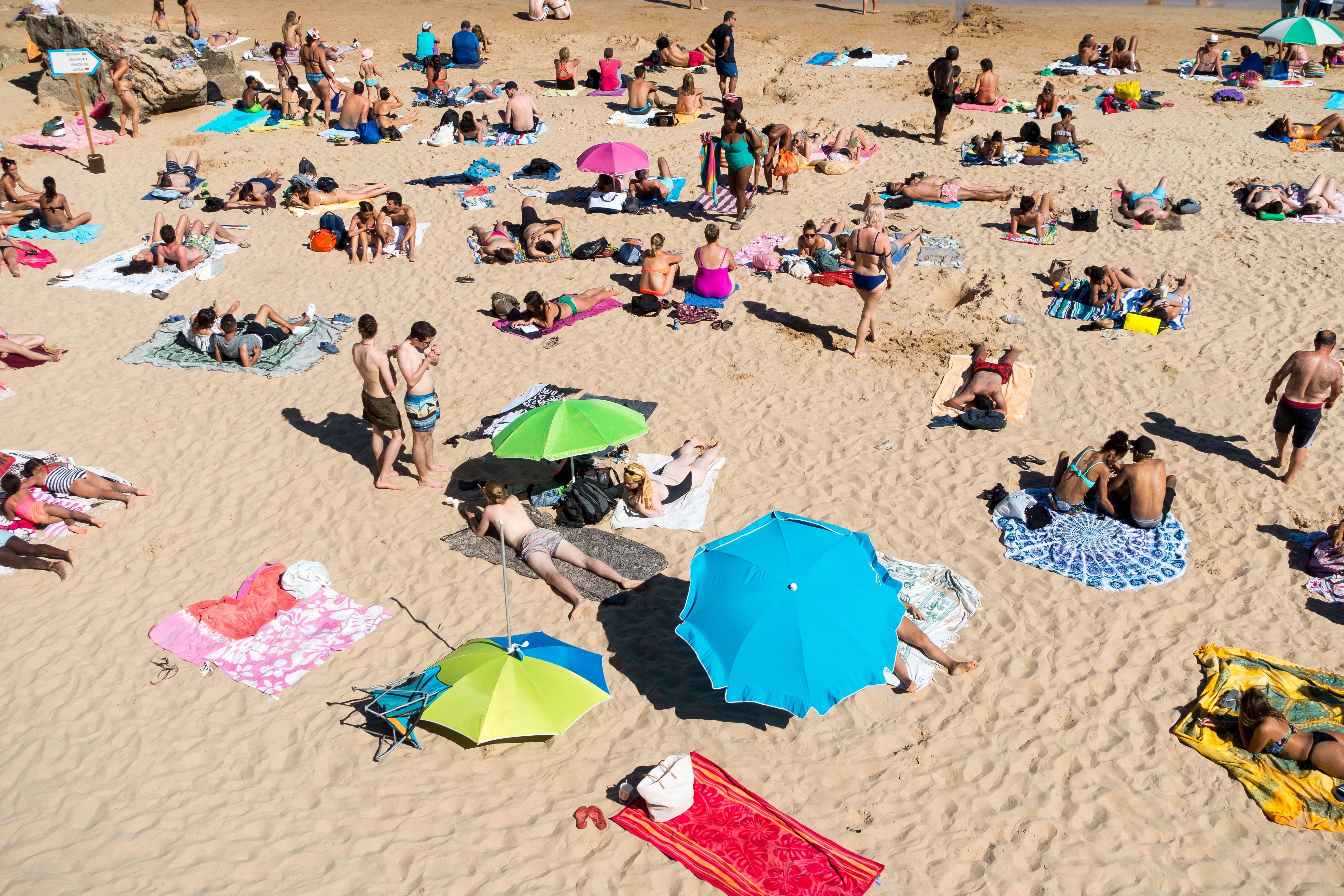 Homokos tengerparton napozó tömeg
