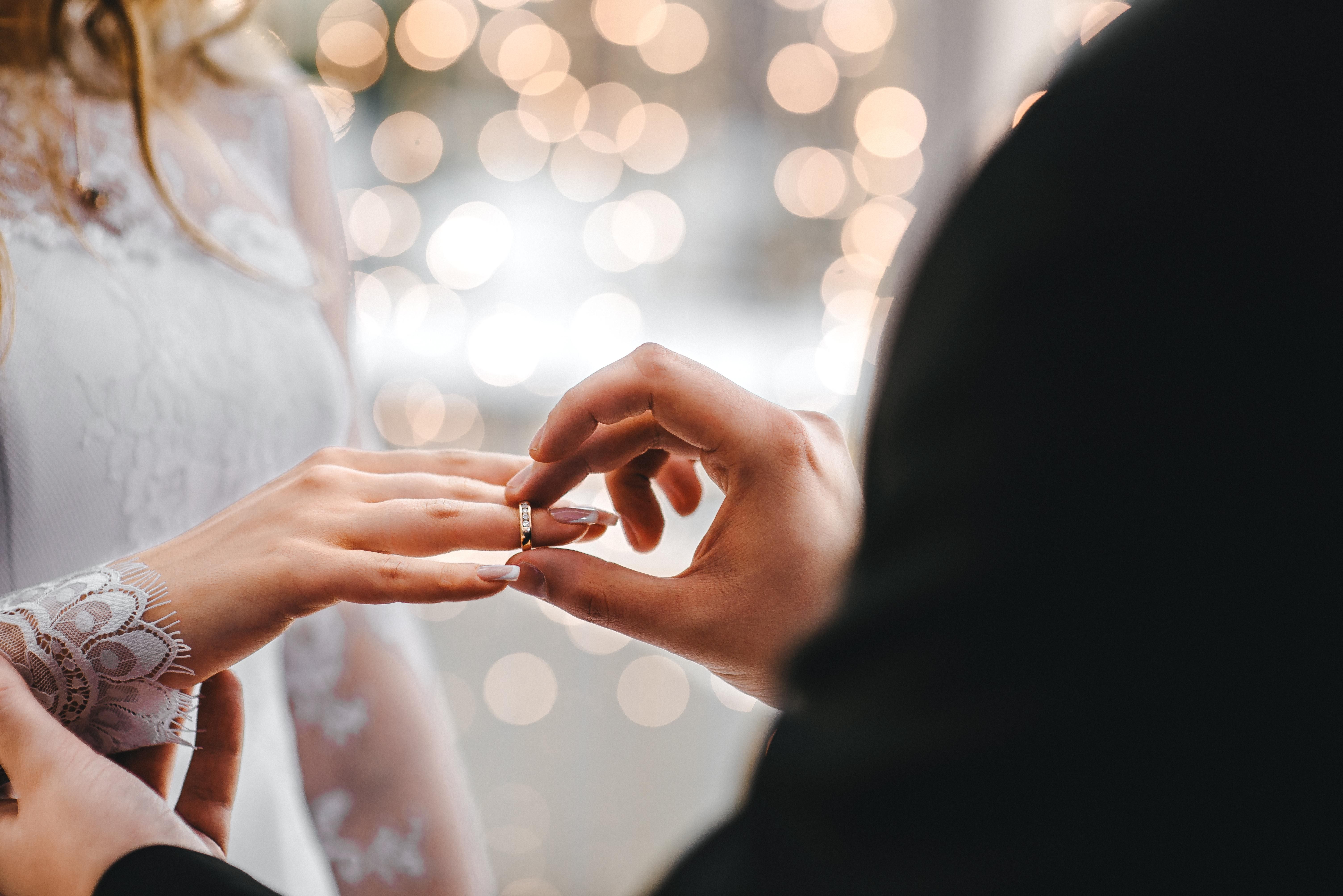 A férj felhúzza a gyűrűt a felesége ujjára az esküvőn